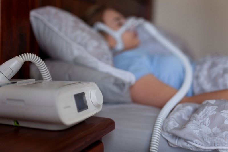 woman sleeping with CPAP machine