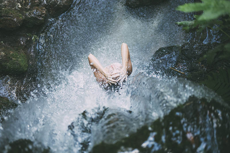 woman taking a bath under the waterfalls