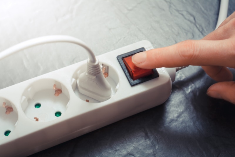 woman turning on power strip