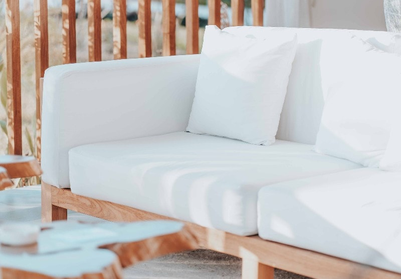 wooden outdoor sofa with white cushions