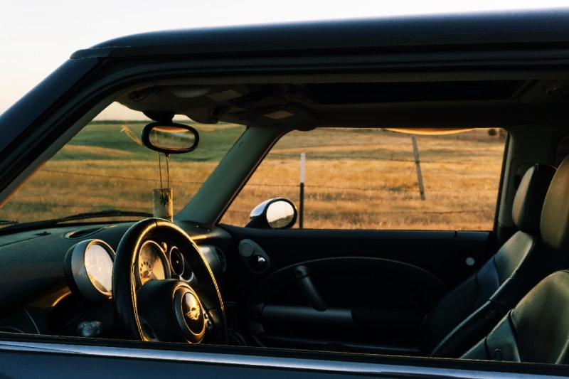 A small pouch hanging from a rearview mirror