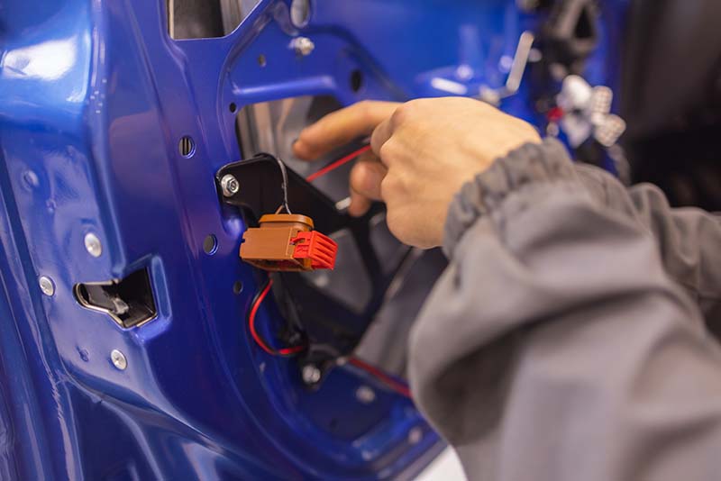 Auto repair technicians in car repair shops are repairing car door systems