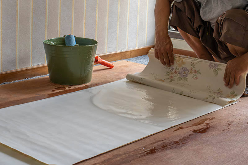Craftsman is folding up wallpaper after glueing process