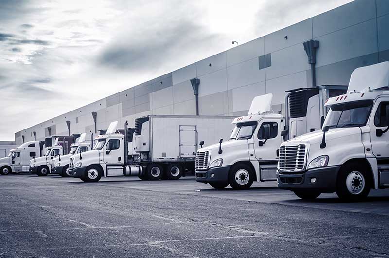 Delivering or Supply concept image. Trucks loading at facility