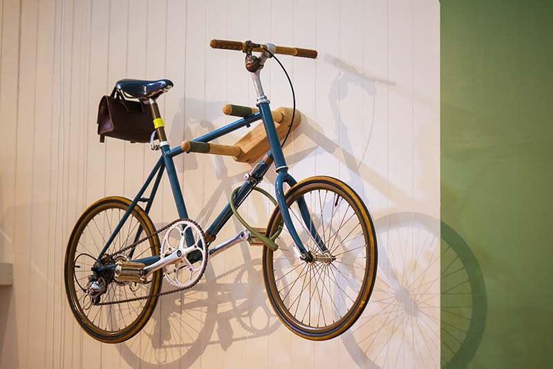 Hang the bike on the wall of the house
