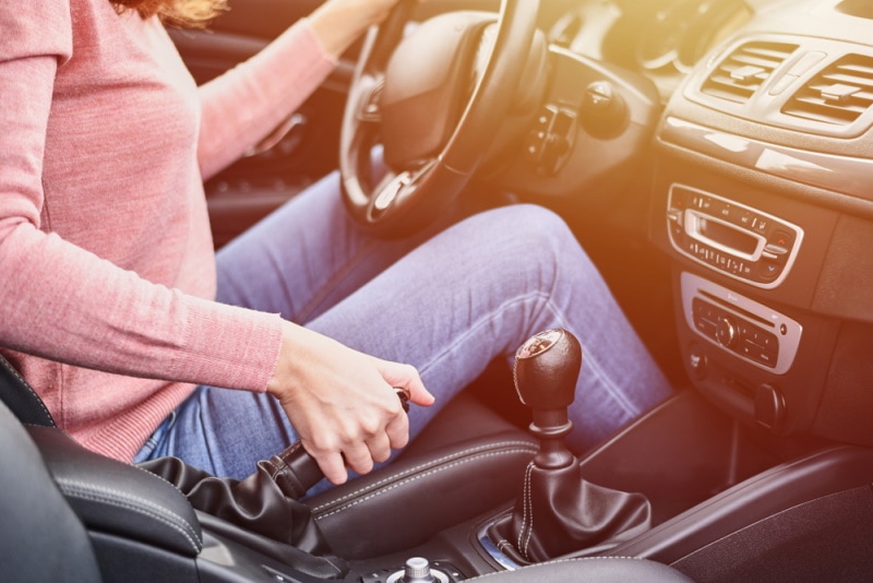 Lady driver pressing the emergency hand brakes in the car