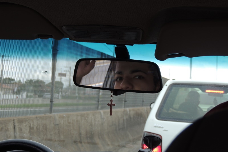 Rearview mirror wirh crucifix hanging from it