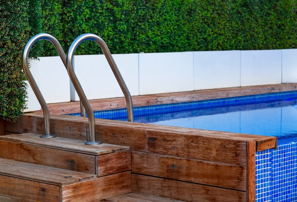 The planking of a swimming pool with stair and turquoise clear water