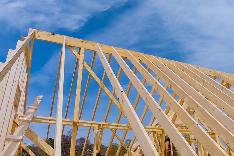 Timber frame beam framework stick built home with roof under construction
