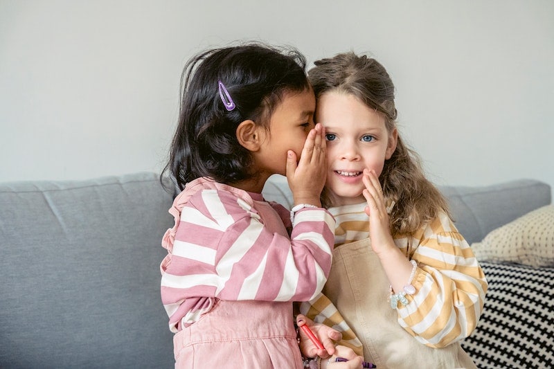 Two children whispering