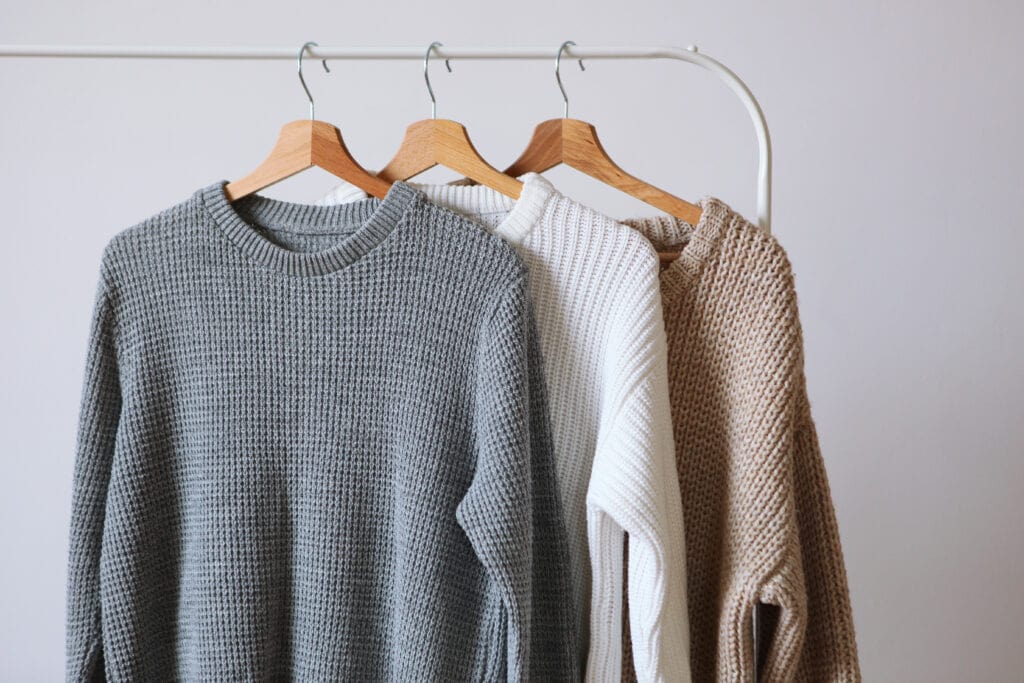 Warm,Sweaters,On,A,Wardrobe,Hanger,On,A,Light,Background.