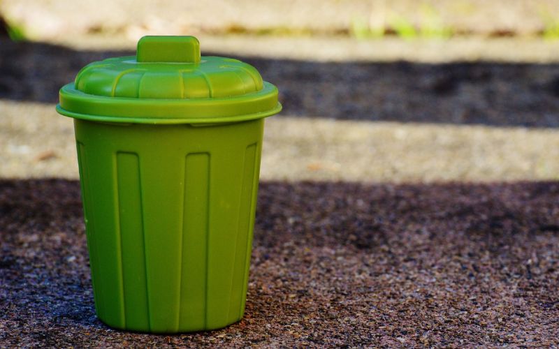 a green plastic trash garbage recycling bin