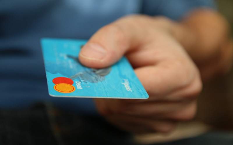 a person holding out a bank card