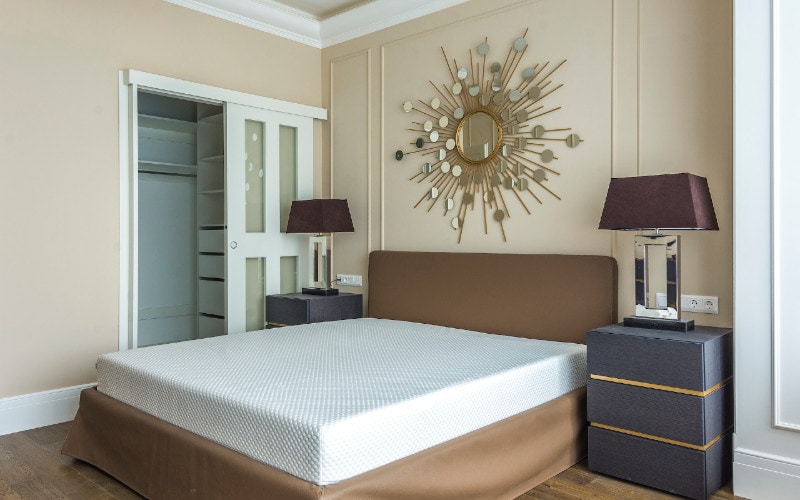 bedroom with mirror decor above bed