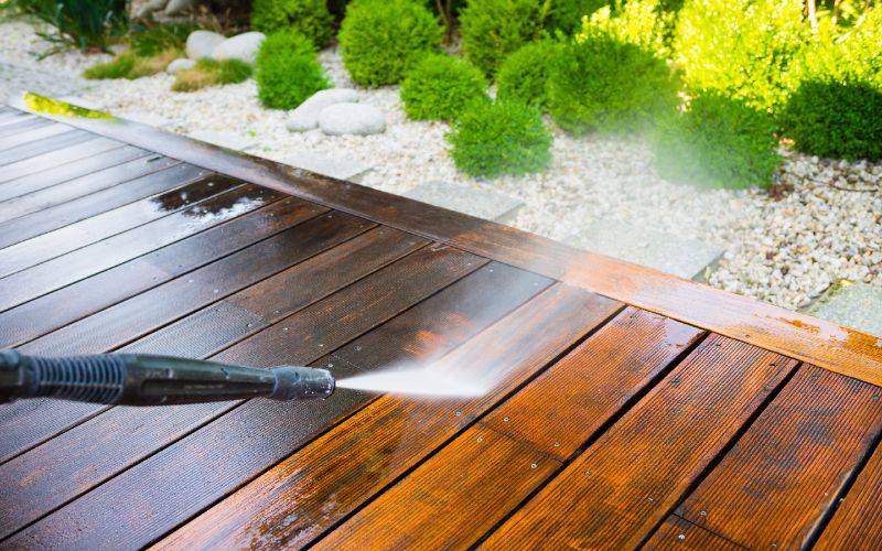 cleaning a wood deck with a pressure washer