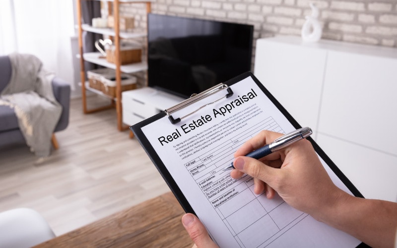close up of a person filling out a real estate appraisal form for a house