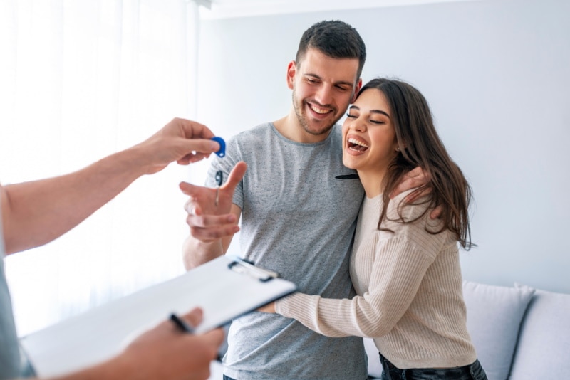 couple taking key of their new house
