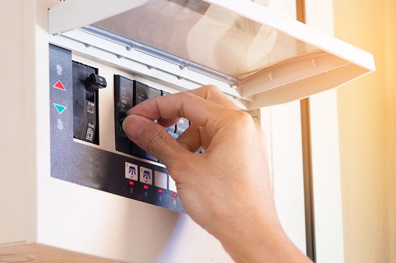 electrician on hand open circuit breaker board