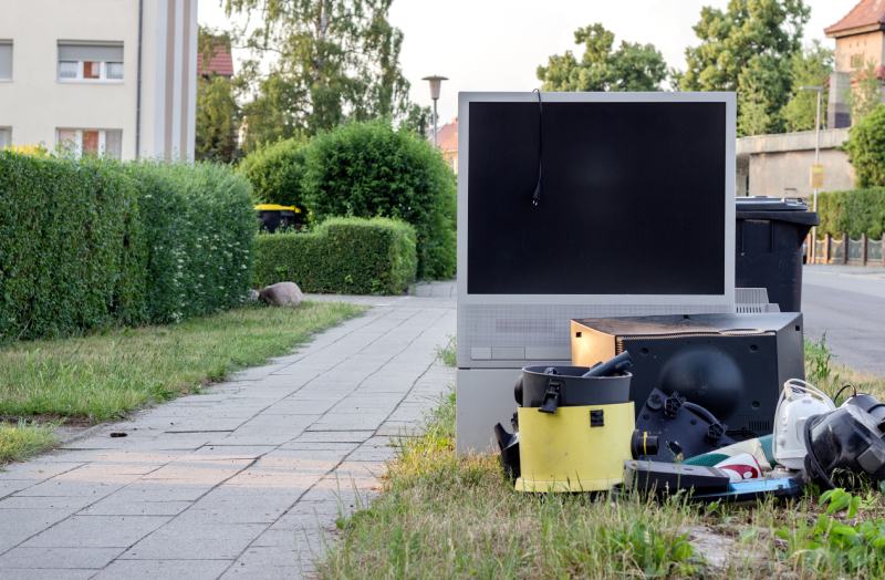 electronic garbage with a television, vacuum and appliances on the roadside