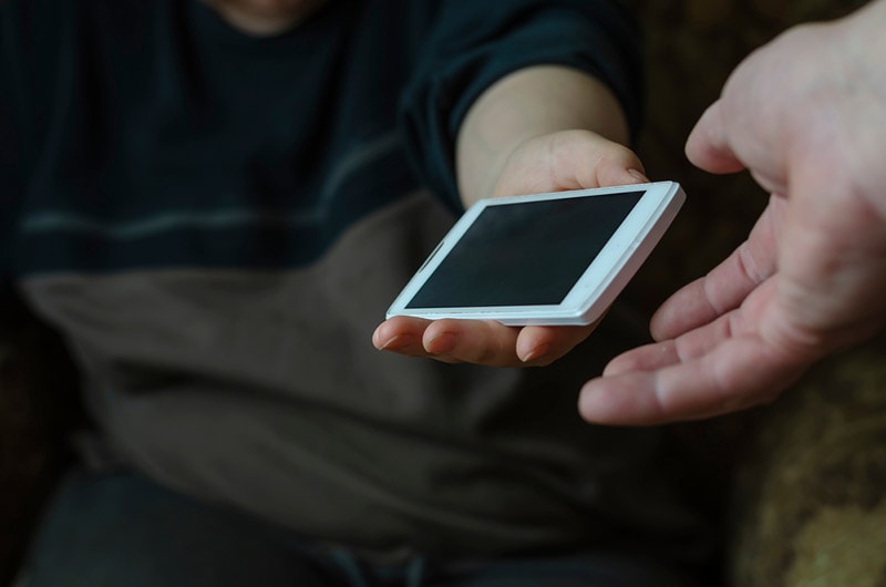 female hand passing mobile phone