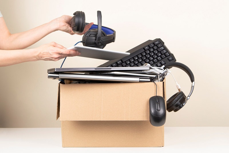 female hands putting old electronics in a box