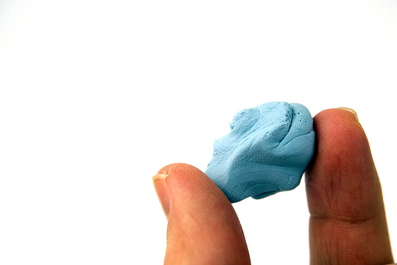 hand holding Blu sticky Tack