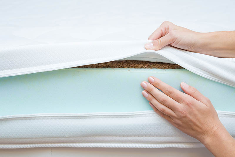 hand showing the different layers on memory foam mattress