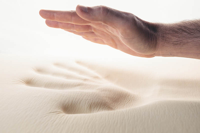Hand testing a memory foam bed