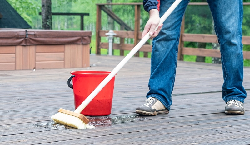 man cleaning wooden deck