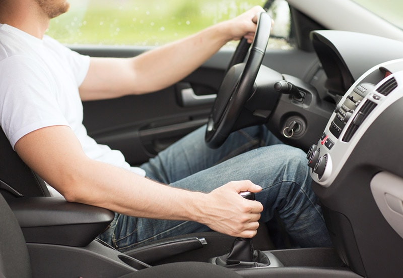 man driving a manual transmission car