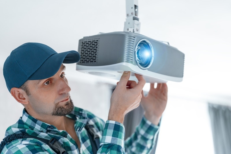 man mounting projector