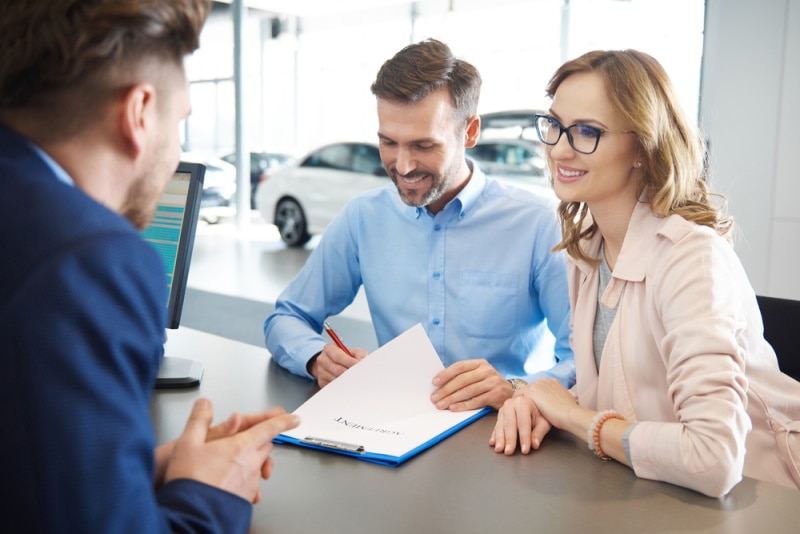 man signing documents of car loan