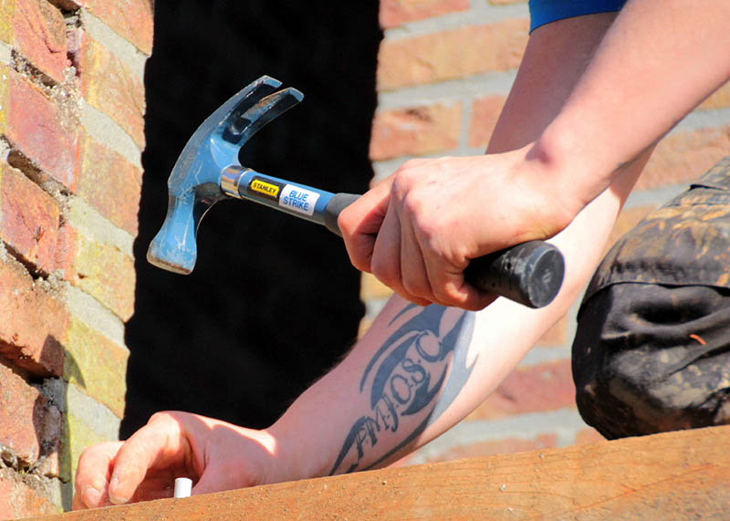 man using claw hammer