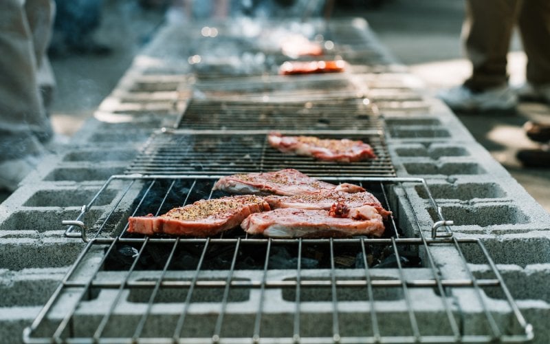 meat cooking on makeshift cinder block bbq grill