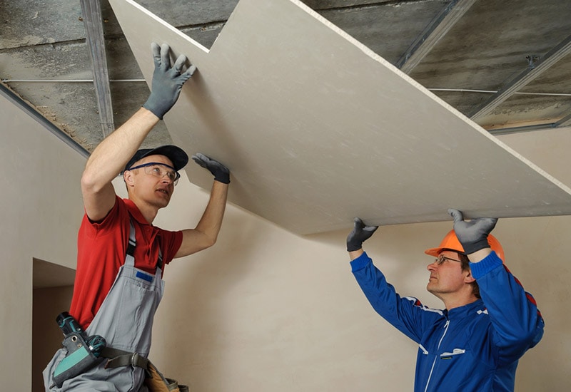 men installing ceiling drywall