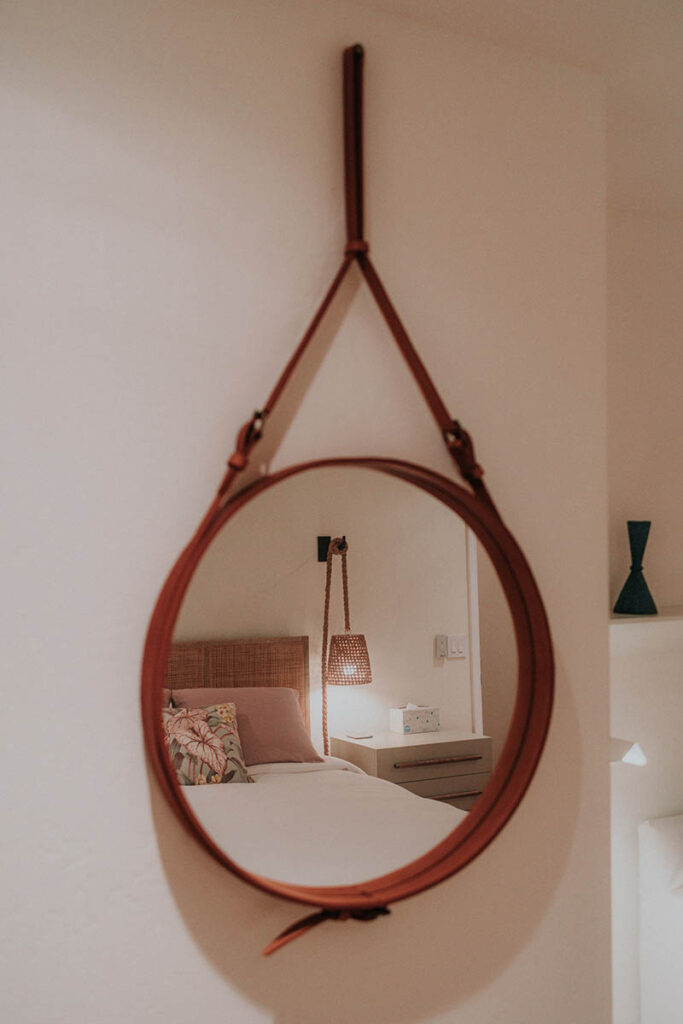 mirror hanging in front of the bed