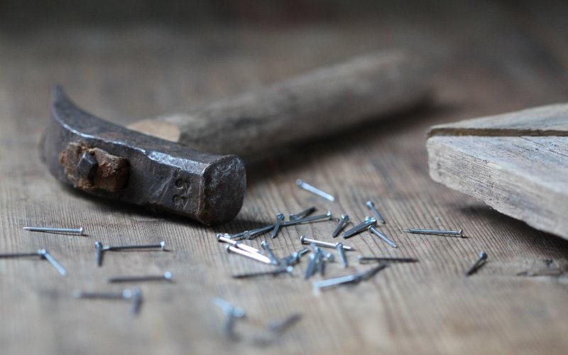 nails and hammer on a wooden surface