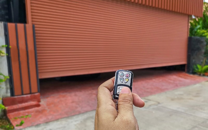 person holding up remote to open garage door