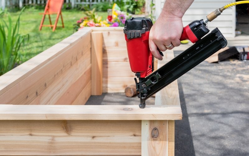 person using a framing nailer nail gun