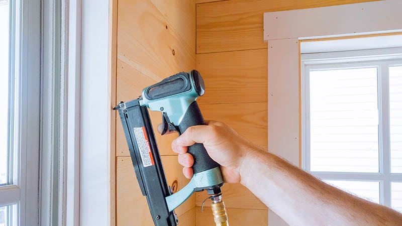 person using brad nailer
