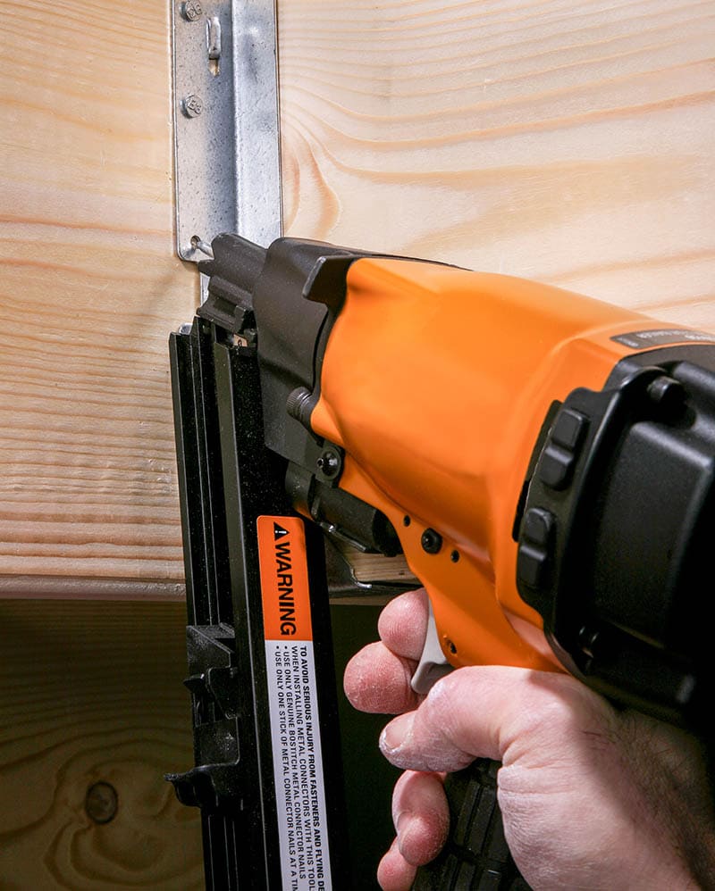 person using framing nailer close up