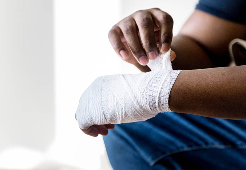 person wrapping hand with bandage