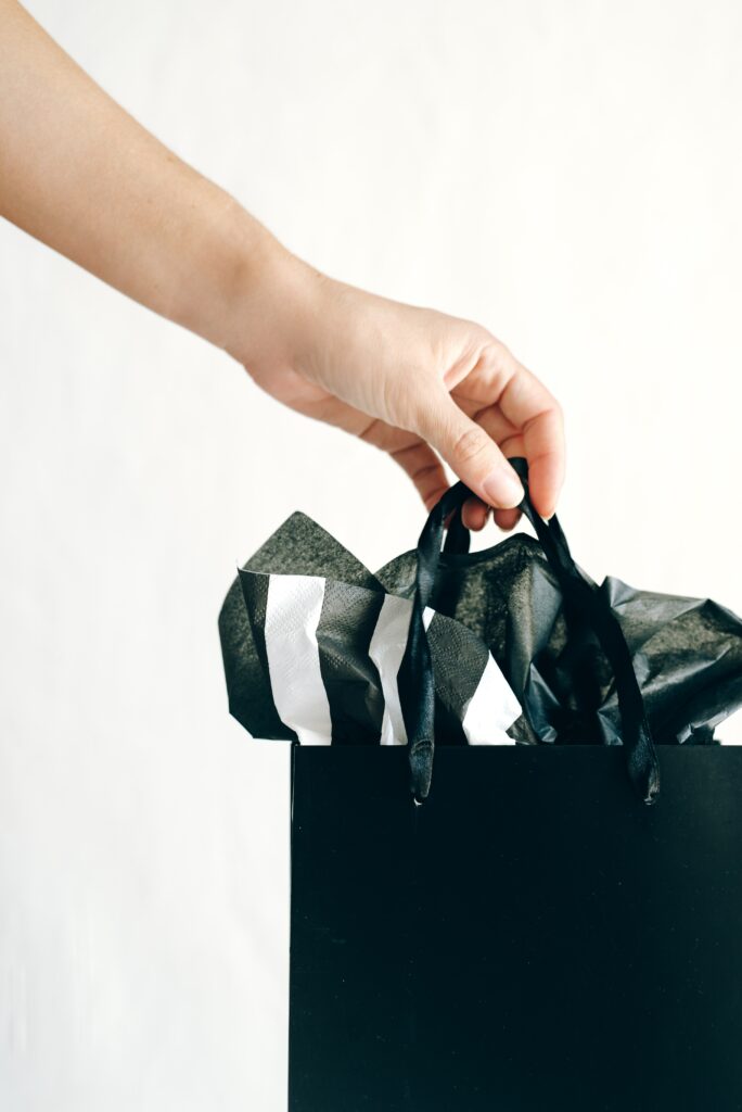 Hand Holding a Shopping Bag with Tissue Paper Inside