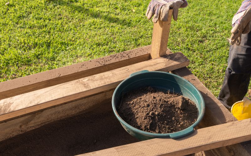 sifting soil through garden sieve