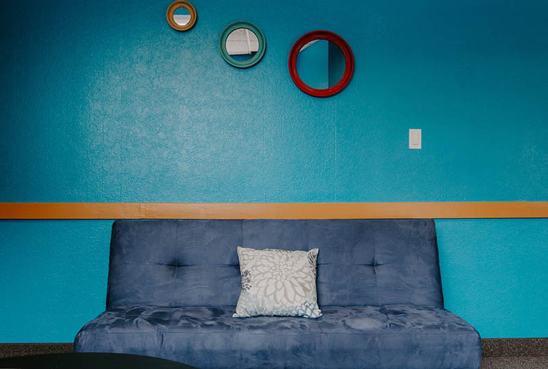 three small mirrors hanging above the couch
