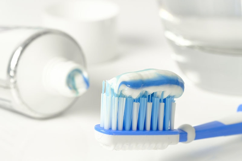 toothpaste tube and a toothbrush with toothpaste
