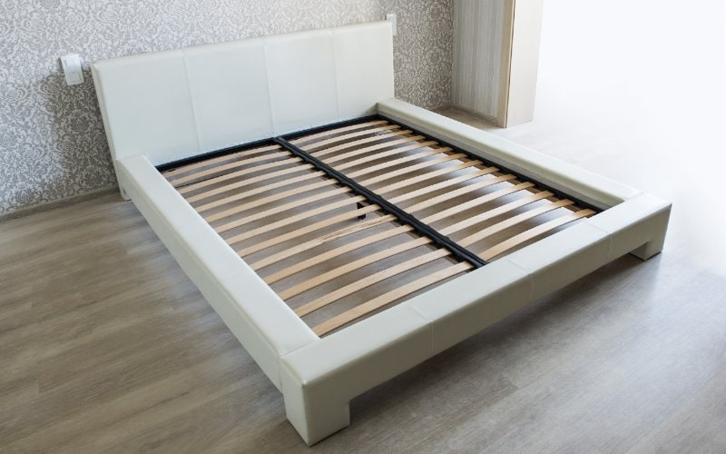 white bed frame with wooden slats without mattress