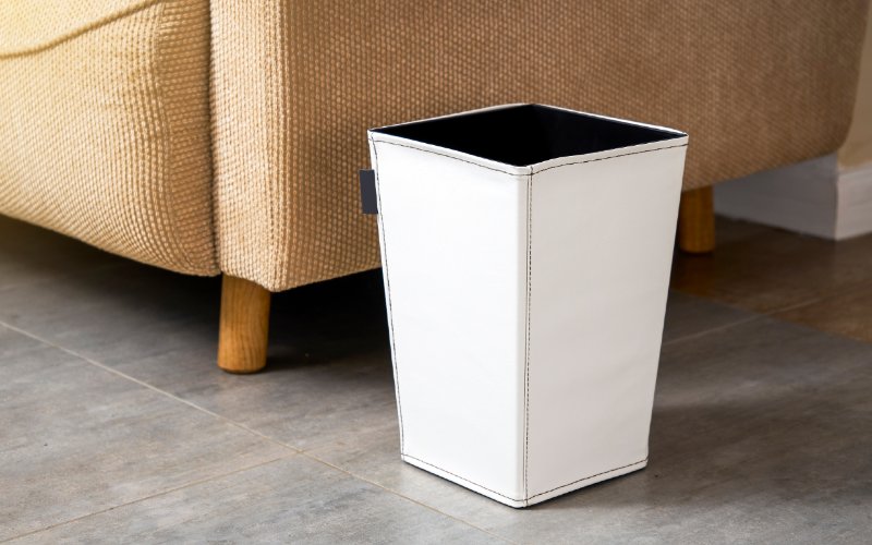 white trash can bin beside a couch in the living room