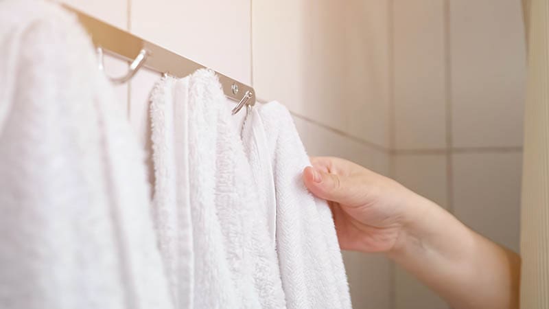 woman removing towel from metal hook