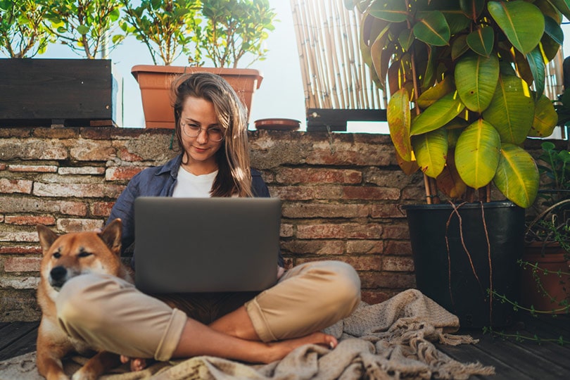 woman working on her laptop with her dog